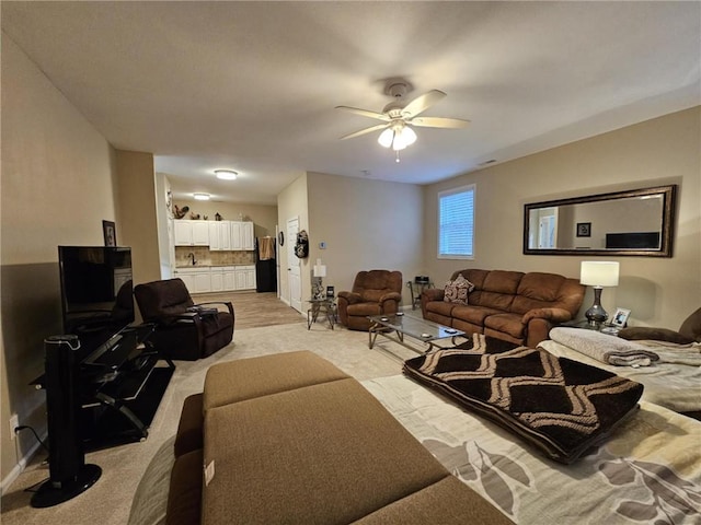 living area with visible vents, a ceiling fan, and light colored carpet