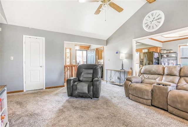 living area with high vaulted ceiling, baseboards, light colored carpet, and a ceiling fan