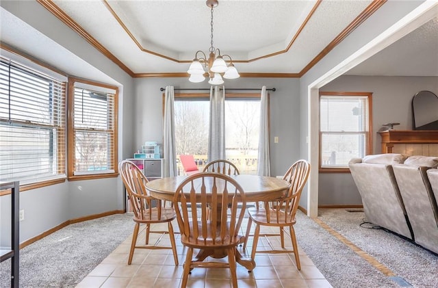 dining area with baseboards, a chandelier, a tray ceiling, ornamental molding, and a textured ceiling