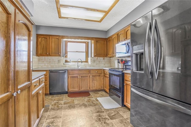 kitchen with backsplash, appliances with stainless steel finishes, light countertops, and brown cabinets