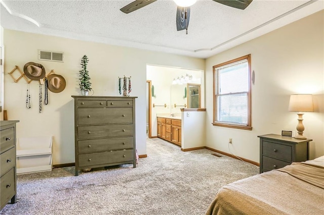 bedroom with visible vents, light carpet, a textured ceiling, and baseboards