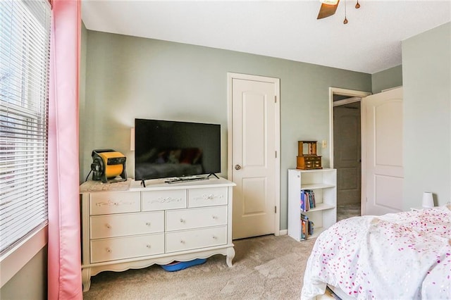 bedroom with light carpet and a ceiling fan