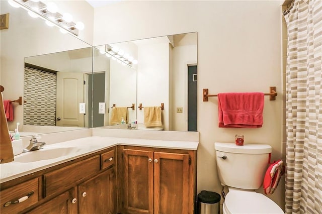 bathroom with toilet, curtained shower, and vanity