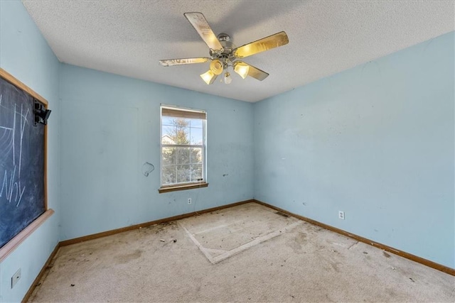 spare room featuring light carpet, a textured ceiling, and a ceiling fan