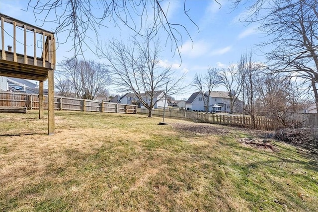 view of yard with a fenced backyard, a residential view, and a deck