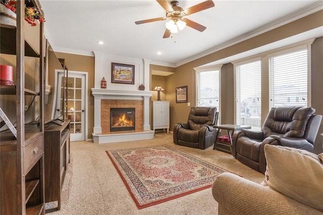 living room featuring crown molding, recessed lighting, a ceiling fan, light carpet, and a tile fireplace