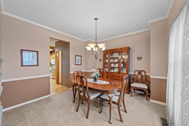 dining room featuring crown molding, light carpet, and a notable chandelier