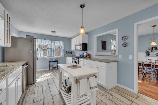 1100 SW Azure Ave, Blue Springs, MO 64015 - kitchen featuring glass insert cabinets, appliances with stainless steel finishes, white cabinets, and light wood finished floors