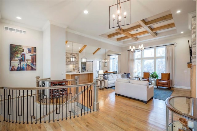 living room featuring light wood-type flooring, visible vents, a chandelier, and beamed ceiling