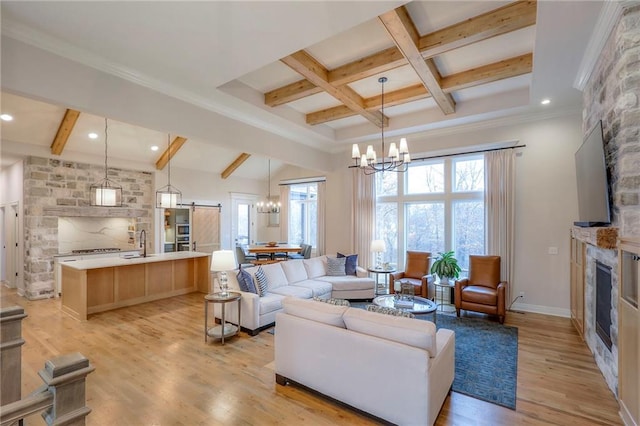 living room with light wood-style flooring, a fireplace, baseboards, beamed ceiling, and an inviting chandelier