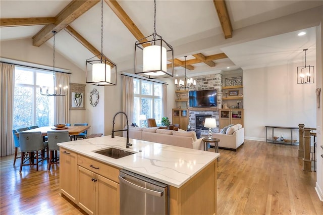 kitchen with stainless steel dishwasher, open floor plan, decorative light fixtures, and an island with sink