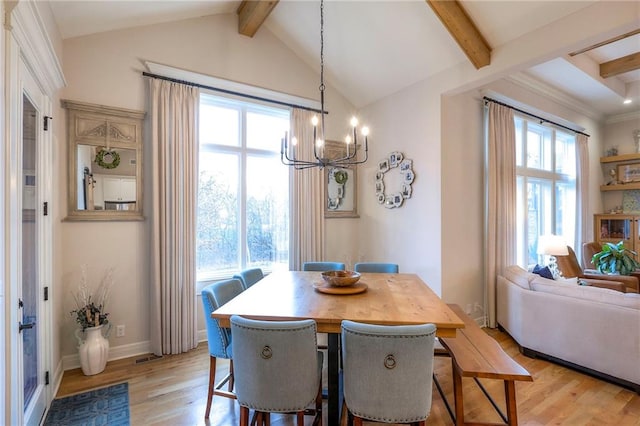 dining area with light wood-style floors, a wealth of natural light, and lofted ceiling with beams