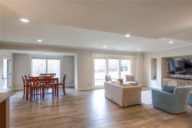 living room featuring a healthy amount of sunlight, crown molding, and wood finished floors