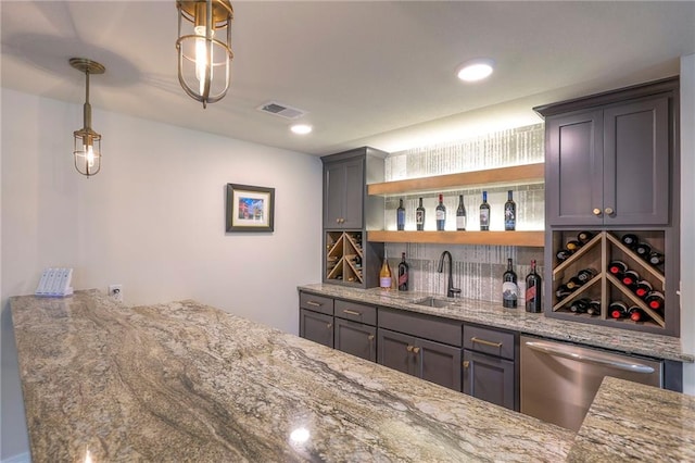 bar with visible vents, hanging light fixtures, stainless steel dishwasher, a sink, and wet bar