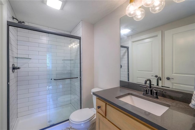 full bathroom featuring vanity, a shower stall, and toilet