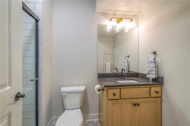 bathroom with toilet, a shower with shower door, baseboards, and vanity