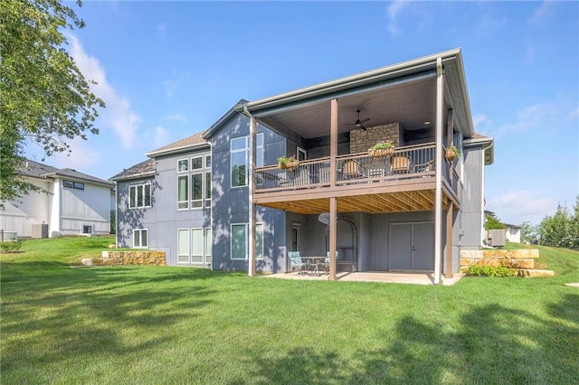 back of house featuring a yard, ceiling fan, a wooden deck, and a patio