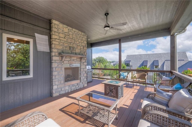 deck with ceiling fan and an outdoor living space with a fireplace