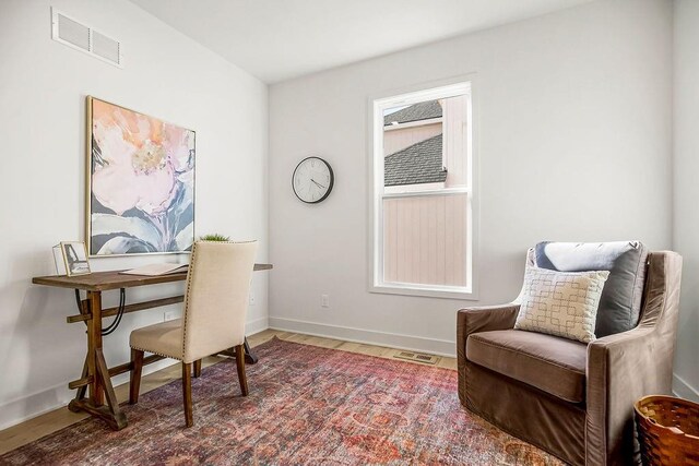 home office featuring wood finished floors, baseboards, and visible vents