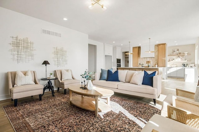 living area with visible vents, recessed lighting, and light wood-type flooring