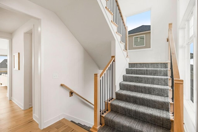 staircase with baseboards and wood finished floors