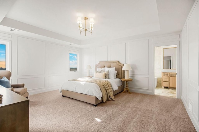 carpeted bedroom featuring a raised ceiling, a decorative wall, visible vents, and a chandelier