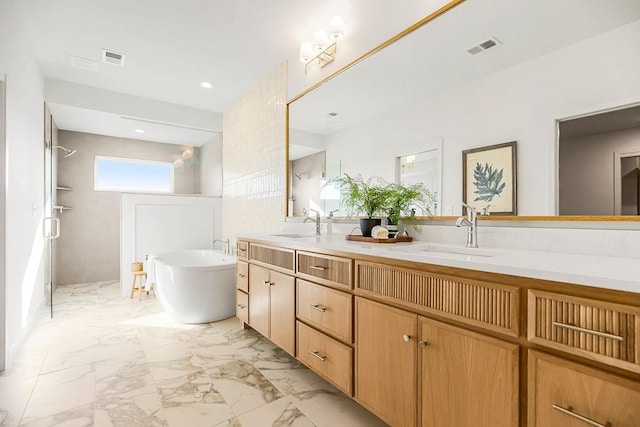 bathroom featuring visible vents, marble finish floor, a sink, double vanity, and a freestanding bath