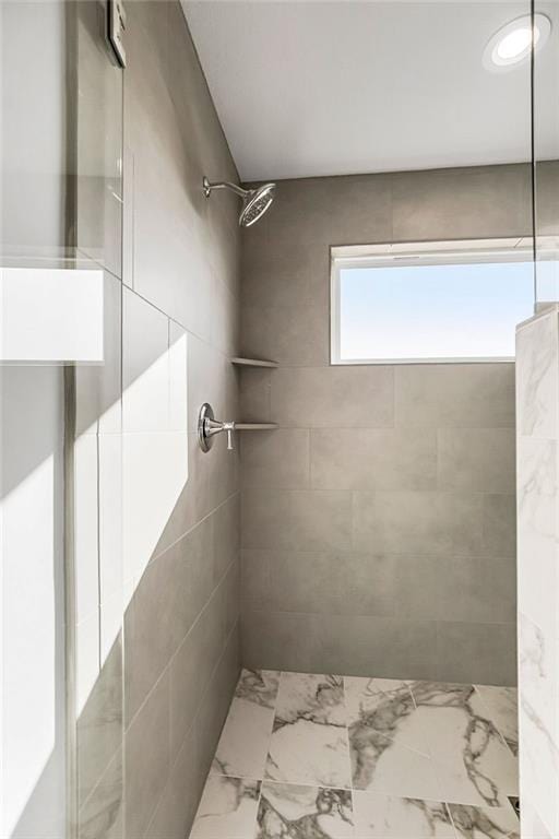 bathroom featuring marble finish floor and tiled shower