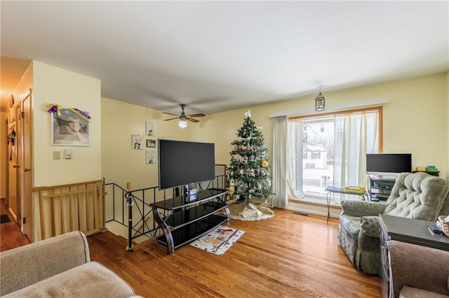 living area with ceiling fan and wood finished floors