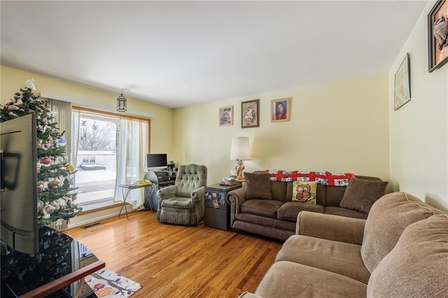 living room featuring visible vents and wood finished floors