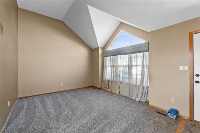 empty room featuring lofted ceiling, carpet floors, and baseboards