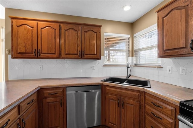 kitchen with tasteful backsplash, dishwasher, brown cabinets, light countertops, and a sink