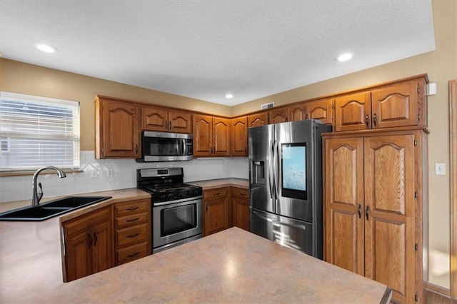 kitchen featuring decorative backsplash, brown cabinetry, appliances with stainless steel finishes, light countertops, and a sink