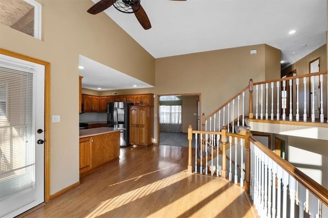 stairs with baseboards, wood finished floors, a towering ceiling, and recessed lighting