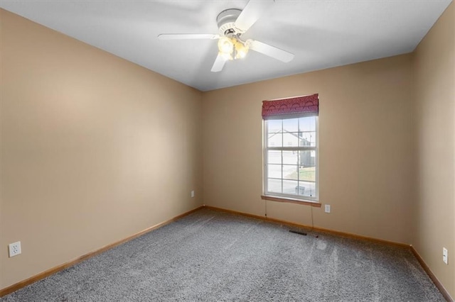 spare room with carpet floors, visible vents, ceiling fan, and baseboards