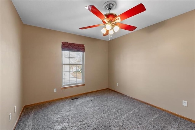 empty room featuring ceiling fan, carpet, visible vents, and baseboards