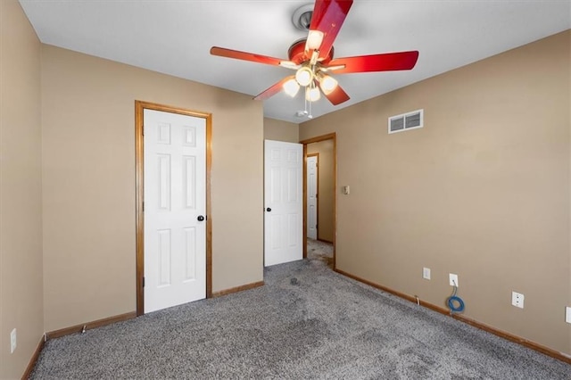 unfurnished bedroom with ceiling fan, carpet floors, visible vents, and baseboards