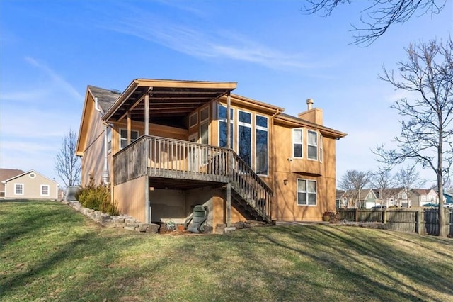 back of property featuring a chimney, a lawn, stairway, and fence