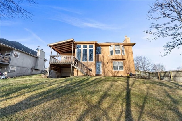 rear view of property featuring a chimney, a lawn, fence, and stairs