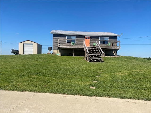 view of front facade featuring stairs, a deck, an outdoor structure, a shed, and a front yard