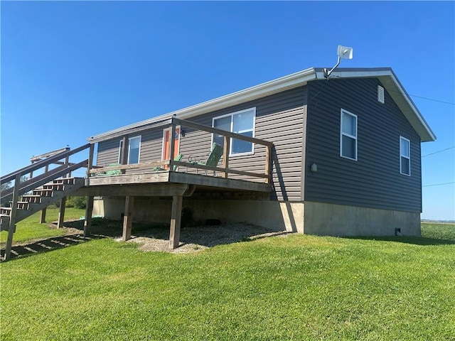 view of side of home with a deck, a lawn, and stairway