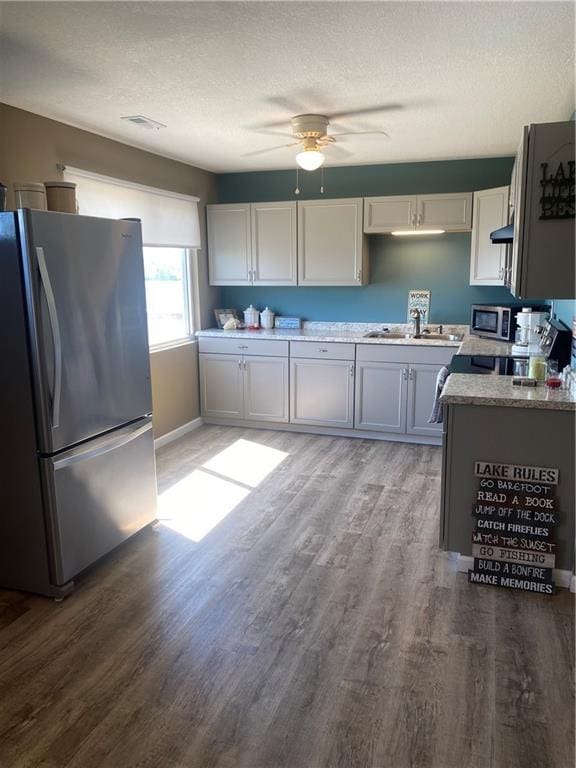 200 Ramsey Dr, Craig, MO 64437 - kitchen featuring a textured ceiling, stainless steel appliances, and wood finished floors