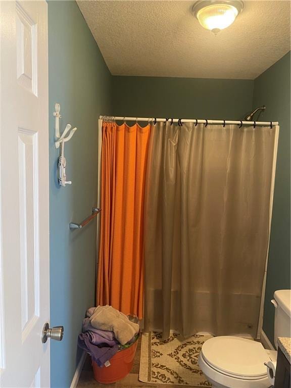 200 Ramsey Dr, Craig, MO 64437 - full bathroom featuring toilet, a shower with curtain, a textured ceiling, and vanity