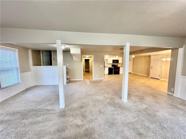 basement with stairs, a wainscoted wall, and light colored carpet