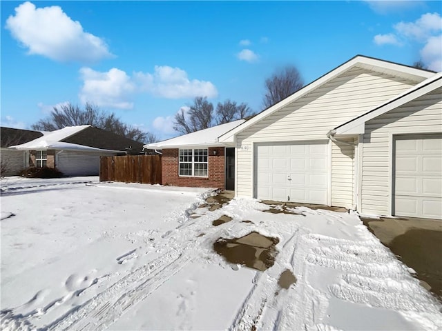 single story home with a garage, brick siding, and fence