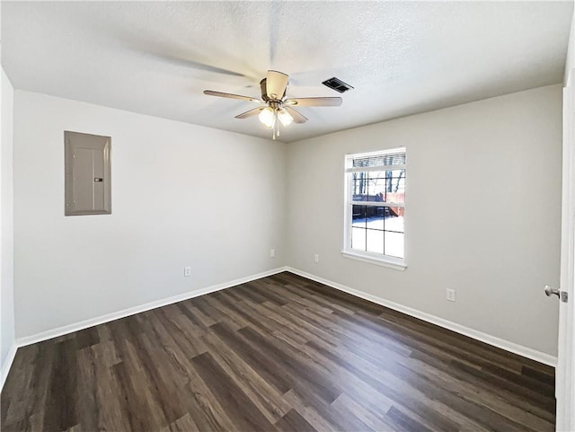 unfurnished room featuring ceiling fan, dark wood-type flooring, visible vents, baseboards, and electric panel