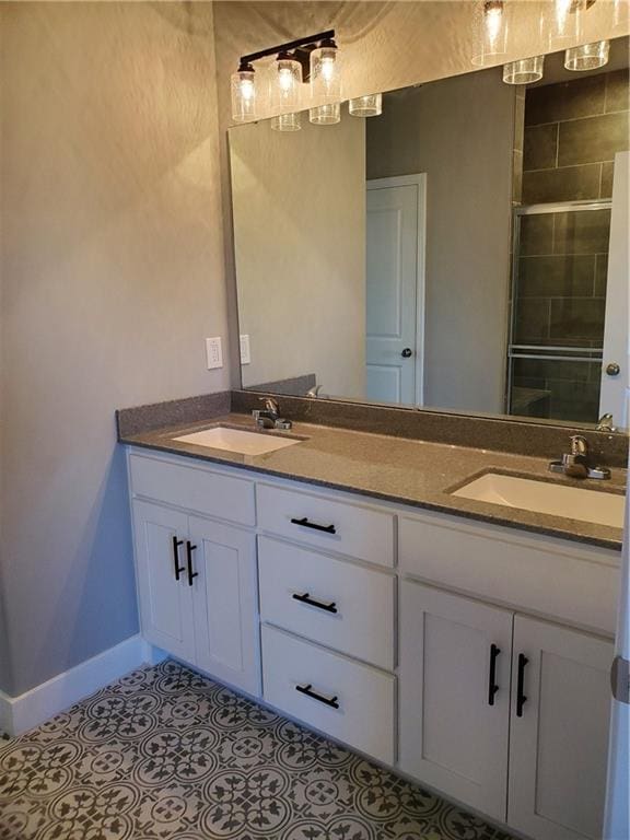 bathroom with double vanity, tile patterned flooring, baseboards, and a sink