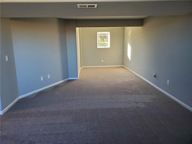 spare room featuring carpet floors, visible vents, and baseboards