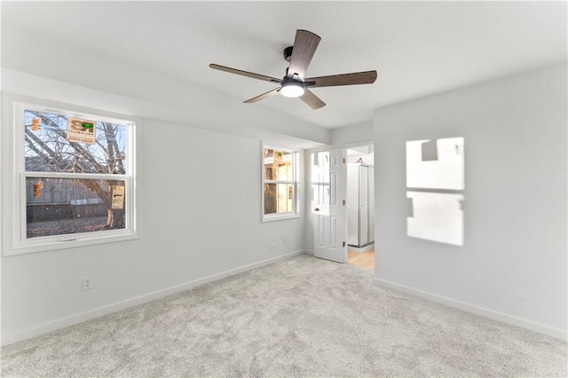 unfurnished bedroom with ceiling fan, baseboards, and light colored carpet