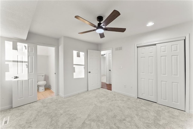 unfurnished bedroom featuring carpet, connected bathroom, visible vents, and baseboards